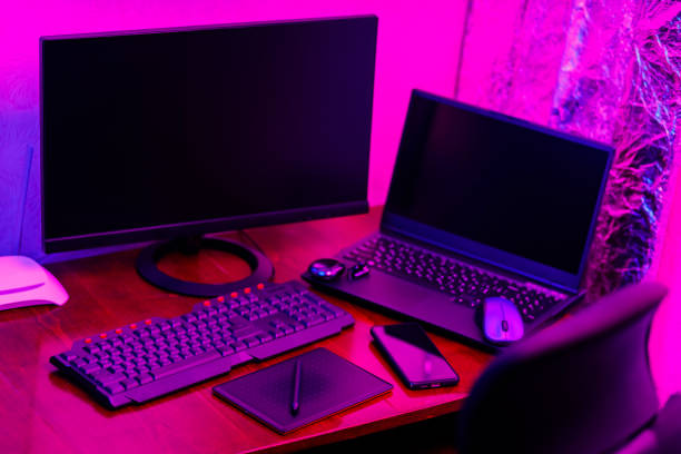istock Creative designer's workplace, back view. Office chair and work desk view with graphic tablet, computer and smartphone. Retoucher home office in neon pink blue 1426906209