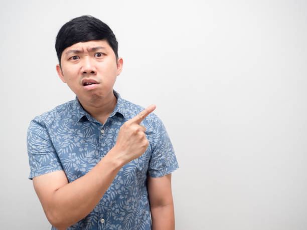 istock Man blue shirt angry face point finger at copy space isolated 1426914166