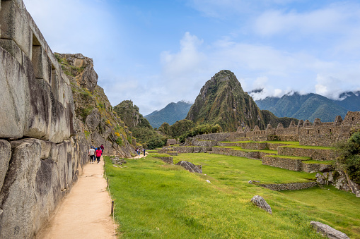 Machu Picchu, Aguas Calientes, Peru - May 4, 2022; Machu Picchu is a 15th-century Inca citadel located in the Eastern Cordillera of southern Peru on a 2,430-meter (7,970 ft) mountain ridge. It is located in the Machupicchu District within Urubamba Province  above the Sacred Valley, which is 80 kilometers (50 mi) northwest of Cusco. The Urubamba River flows past it, cutting through the Cordillera and creating a canyon with a tropical mountain climate.

Most recent archaeologists believe that Machu Picchu was constructed as an estate for the Inca emperor Pachacuti (1438–1472). Often referred to as the 