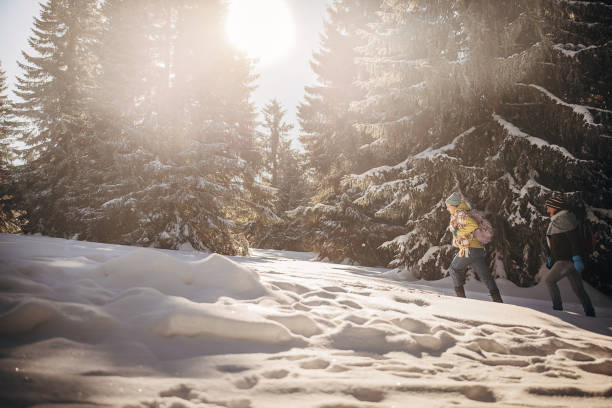 Man and woman, father and his adult daughter exploring nature together during winter days.