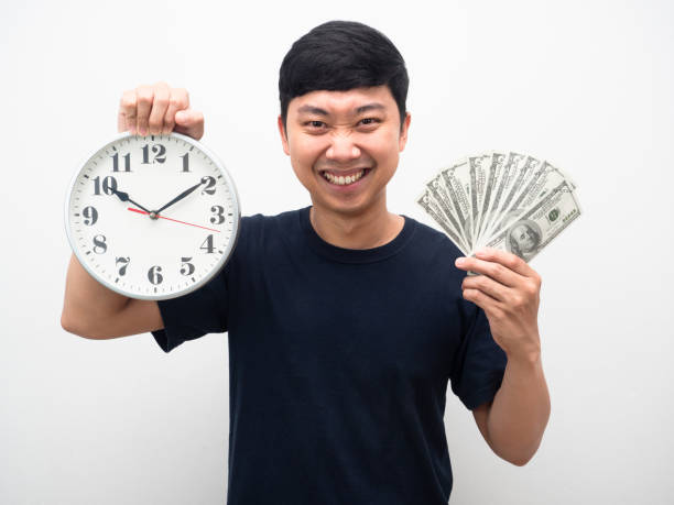 retrato homem camisa preta segurando um monte de dinheiro com relógio analógico na mão sorriso felicidade - clock wall clock face clock hand - fotografias e filmes do acervo