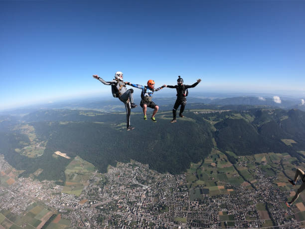 i paracadutisti cadono a testa in giù, in volo aereo - european alps women summer outdoor pursuit foto e immagini stock