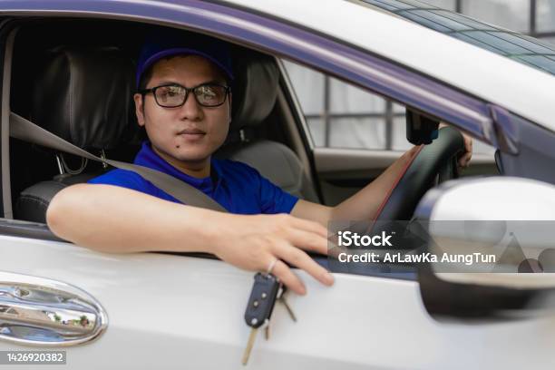 A Young Man Shows His Car Keys While Sitting In The Front Seat Thumbs Up And Holding The Key The Idea Of Renting A Car Or Buying A Car Stock Photo - Download Image Now