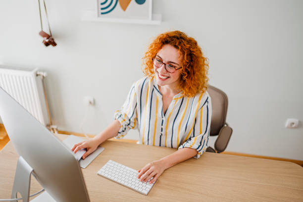 istock Portrait of redhead woman using computer at office 1426922429