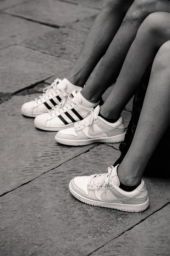 Siena, Italy - August 17 2022: Legs and White Sneakers on the Street