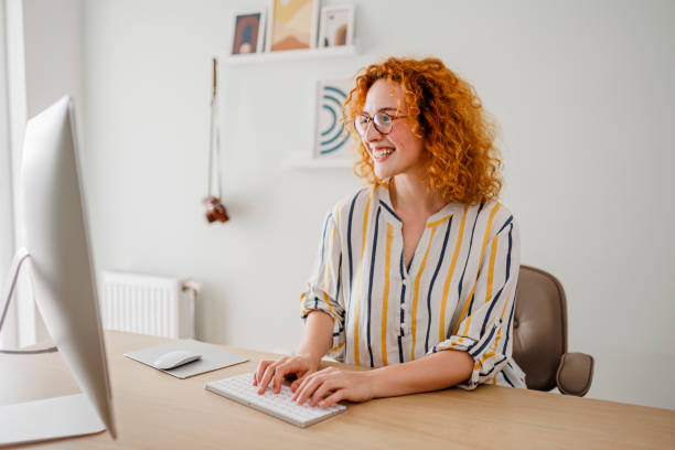 istock Portrait of redhead woman using computer at office 1426922833