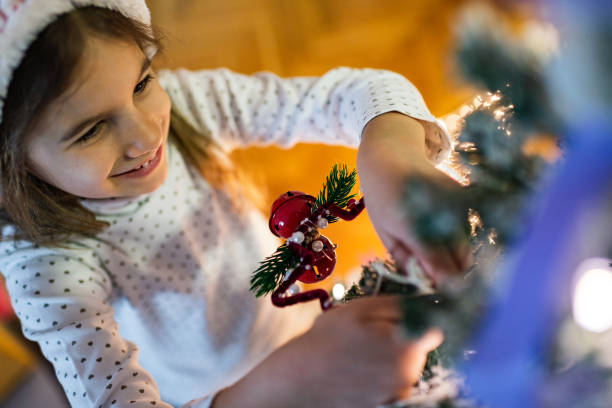 Beautiful girl on a New Year’s Eve decorating Christmas Tree.