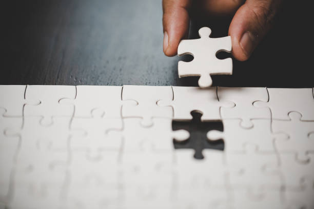 Business woman person hand with puzzle piece idea for strategy and solution. Closeup part of two white jigsaw connect together. Concept of join cooperation success teamwork-problem corporate team. stock photo