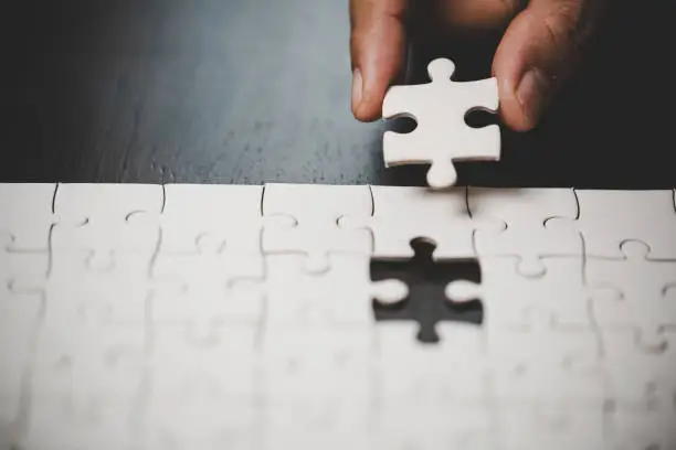 Business woman person hand with puzzle piece idea for strategy and solution. Closeup part of two white jigsaw connect together. Concept of join cooperation success teamwork-problem corporate team.