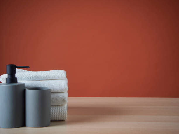 istock Clean towels and Soap dispenser on wooden table. 1426934940