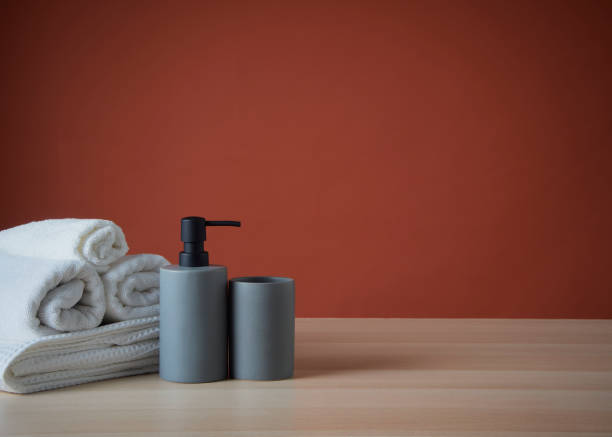istock Clean towels and Soap dispenser on wooden table. 1426934964