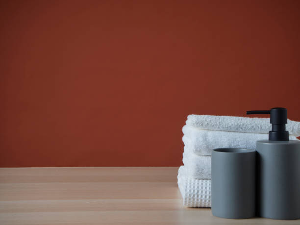 istock Clean towels and Soap dispenser on wooden table. 1426934976