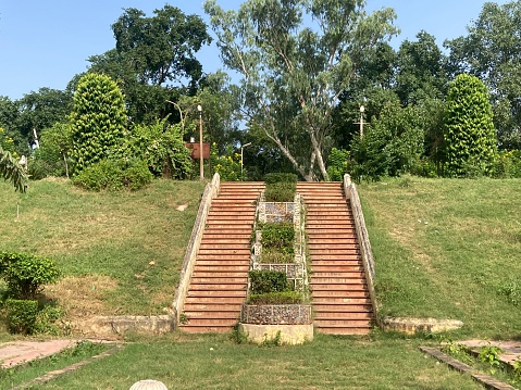 Landscape of long winding stairs in the town, long stone steps iin a park leading up a hill with metal handrail