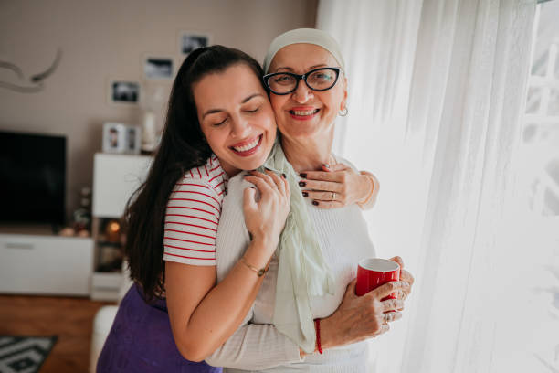 The daughter arranges a scarf for her mother, cancer stock photo