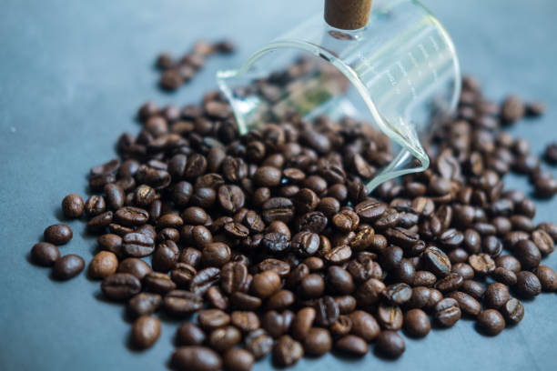istock Scattered coffee beans from a transparent glass 1426938075