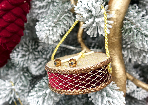 Christmas tree decorated with a toy drum close-up.