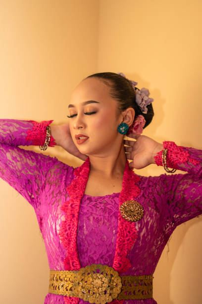 sposa balinese che indossa l'abito da sposa rosa prima dell'inizio della cerimonia - danza del legong immagine foto e immagini stock