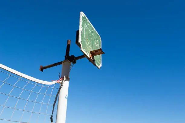Old and damaged basketball board, against clear blue sky