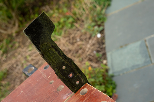 A Rotary lawn mower blade in a vice after sharpening.