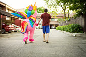 Man with a person in unicorn costume walking outdoors