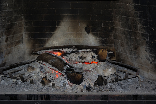Firewood is burning in a stone fireplace. Decoration, cooking, space heating