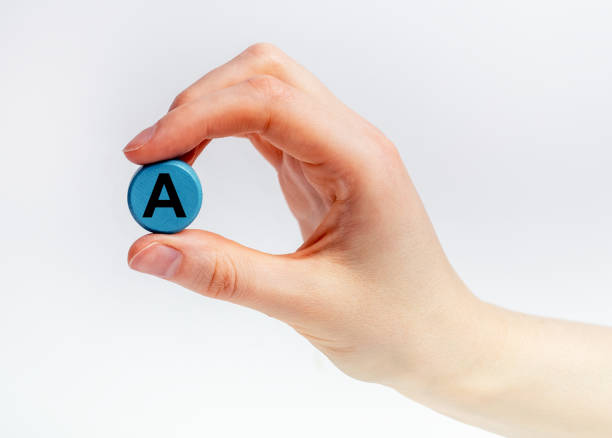 istock A vitamin round pill between fingers closeup 1426966315