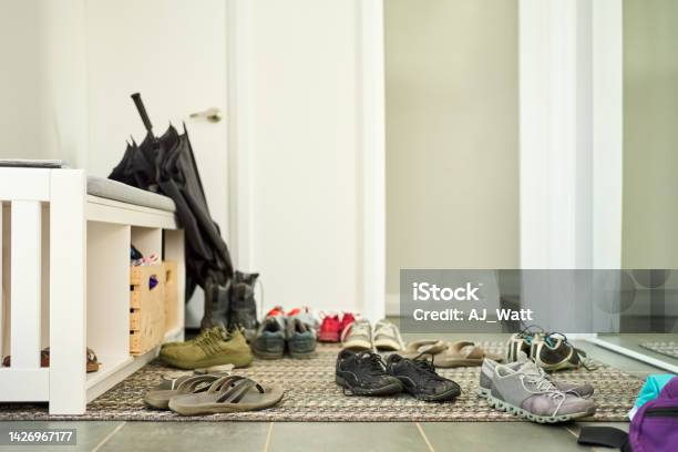 Shoes Scattered On Door Mat At Home Stock Photo - Download Image Now - Corridor, Messy, Shoe