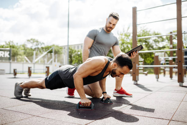 istock Fitness instructor and Latin trainee on outdoor training, man is stretching and doing push ups 1426974301