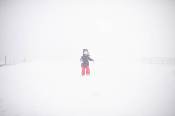 Full length portrait of happy young woman looking on beautiful winter snowy view. Woman in winter clothes walking alone in snowy nature. Full-length portrait of a person enjoying a cold day