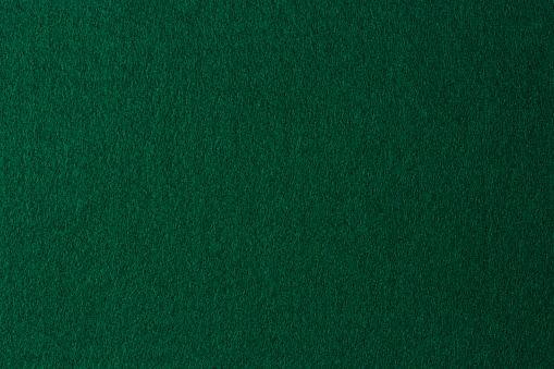 Green color felt textile fabric material texture background. Abstract monochrome dark blue color felt background.