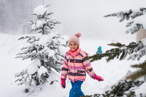 Winter portrait of a beautiful girl having a lot of fun in snow.