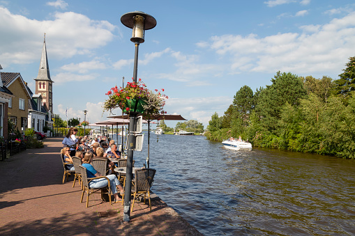 Woudsend, Netherlands on August 11, 2021; People enjoy the water and on the terrace in the picturesque town Woudsen in Friesland.