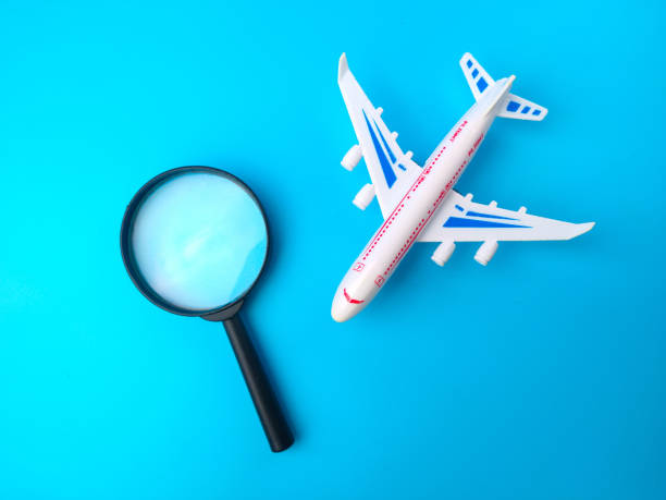 istock Magnifying glass and white toy airplane on a blue background. 1426998475