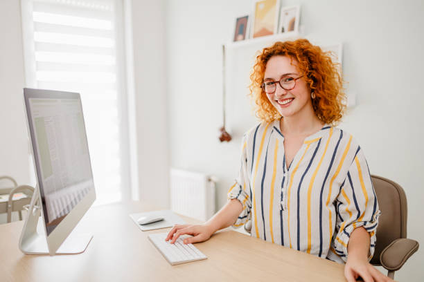 istock Portrait of redhead woman using computer at office 1427000507