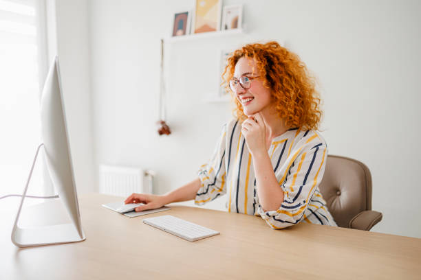 istock Portrait of redhead woman using computer at office 1427000604