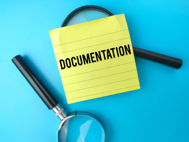 istock Top view magnifying glass and sticky note with the word DOCUMENTATION. Business concept. 1427004560