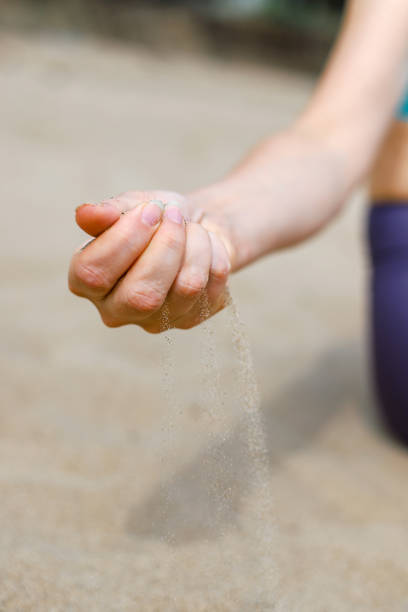 istock Sand falling from woman's hand. Vacation on the beach 1427006800