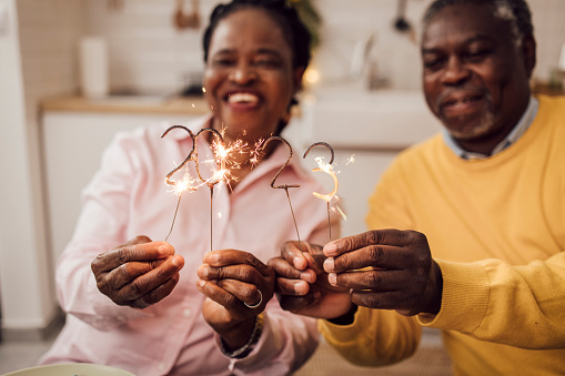 Senior African American couple lighting sprinklers for the 2023 New Year's Eve