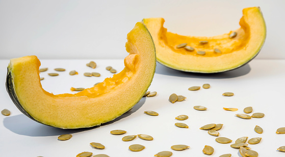 Healthy Eating. Two slices of fresh ripe pumpkin pumpkin with seeds isolated on white background