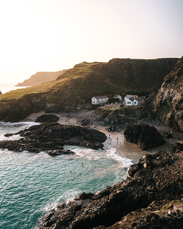 Sunset hues at Kynance cove, a popular swimming spot in the summer on the Lizard Peninsula - sandy beaches, turqoise water.