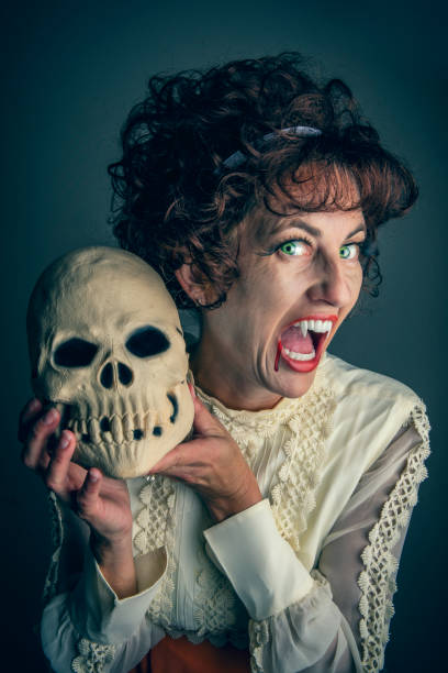 istock Campy 60s Style Woman Vampire Holding a Skull 1427020655
