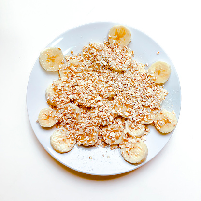 High angle view of delicious slice of fresh banana fruits with flakes of oats