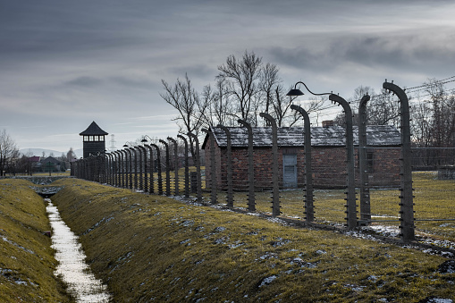 Auschwitz Birkenau, Poland, 9 January 2022: Barrack with wired fence in the Auschwitz II Birkenau nazist extermination camp