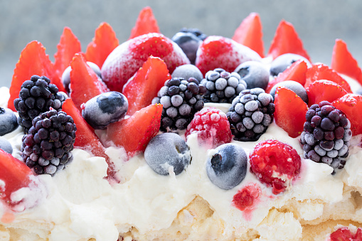 Frozen fruit (strawberries, raspberries, blueberries, blackberries) on meringue and cream. Rapprochement.