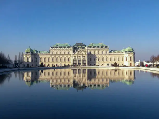 Classic view of famous Schonbrunn Palace with scenic Great Parterre garden on a beautiful sunny day with blue sky and clouds in summer, Vienna, Austria