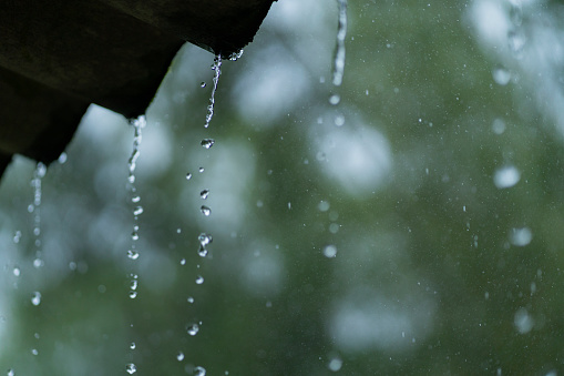 Rain drops on window glass outside texture background water of wonderful heavy rainy day with sky clouds at city blue green blurred lights abstract view sunshine enjoy the relaxing nature wallpaper