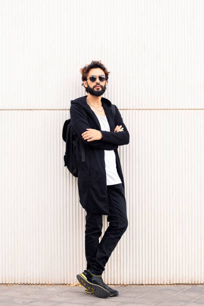 istock young man with sunglasses leaning in a white wall 1427040795
