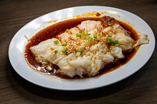 Chinese steamed rice noodle roll cheung fun stuffed shrimp prawn, fried onion garnish, soy sauce and chili paste.