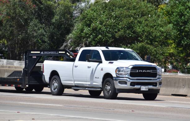 Smiling Hispanic man posing  in front of his pick up truck looking at camera