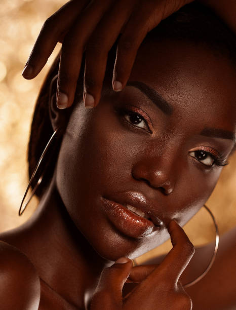 istock Dark skinned beautiful young woman posing sensually on a golden background. 1427078965